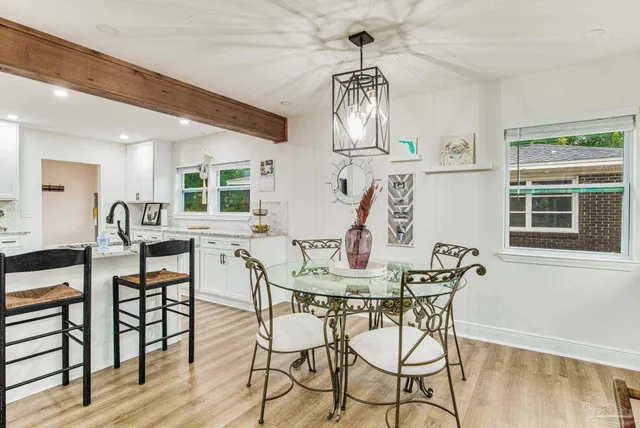 a view of a dining room with furniture a chandelier and wooden floor