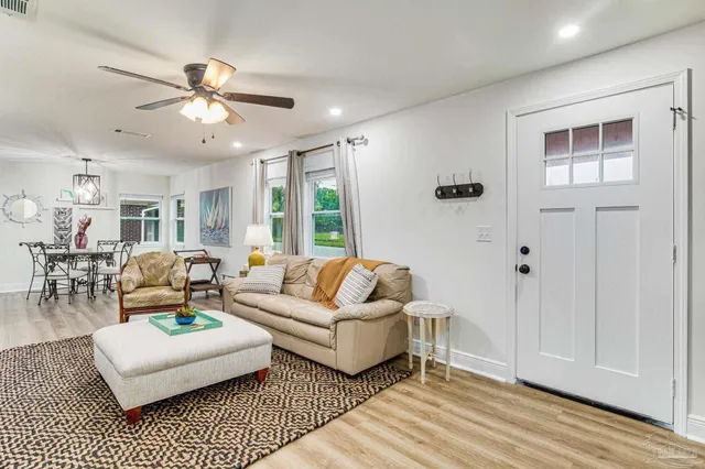 a living room with furniture a ceiling fan and a rug
