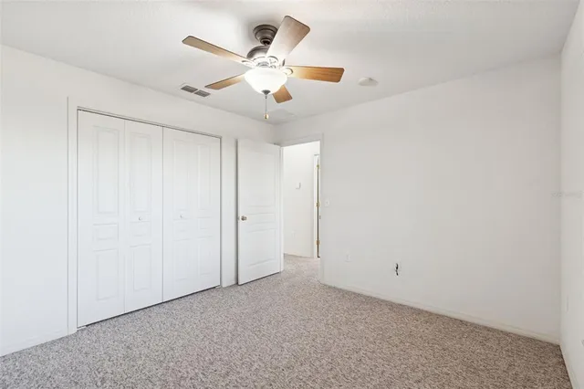 an empty room with a window and a fan