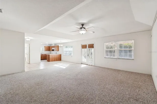 a view of a livingroom with furniture and chandelier fan