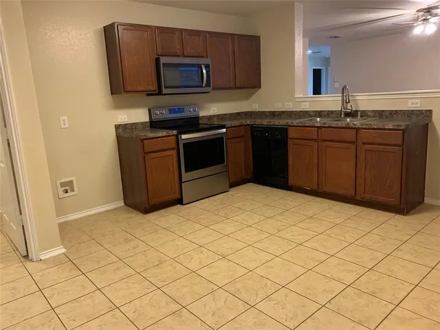 a kitchen with stainless steel appliances a sink and a stove top oven