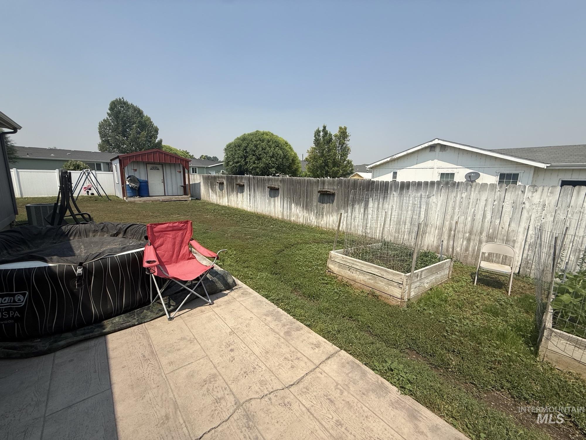 100 Ellsworth Street Vale, OR 97918 - Photo 16 of 25 Spacious backyard featuring an imprinted concrete patio, manicured lawn, and a dedicated garden bed