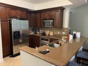 4207 Renaissance Way, Unit 207 Boynton Beach, FL 33426 - Photo 2 of 21 a kitchen with stainless steel appliances granite countertop a sink refrigerator and microwave