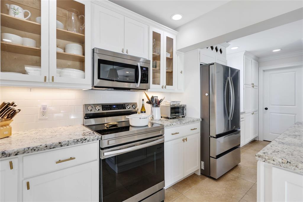 491 Northwest 13th Drive Boca Raton, FL 33486 - Photo 15 of 48 a kitchen with granite countertop a refrigerator stove and microwave