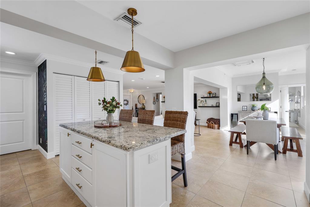 491 Northwest 13th Drive Boca Raton, FL 33486 - Photo 17 of 48 a kitchen with stainless steel appliances kitchen island granite countertop a table and chairs in it