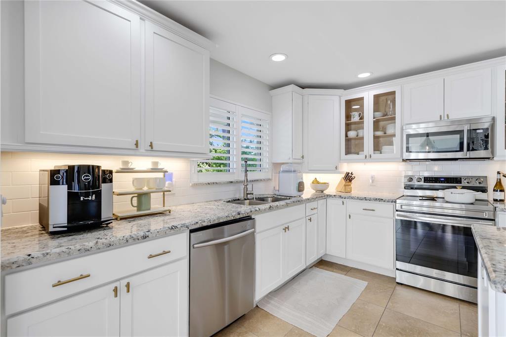 491 Northwest 13th Drive Boca Raton, FL 33486 - Photo 19 of 48 a kitchen with granite countertop a sink stainless steel appliances and white cabinets