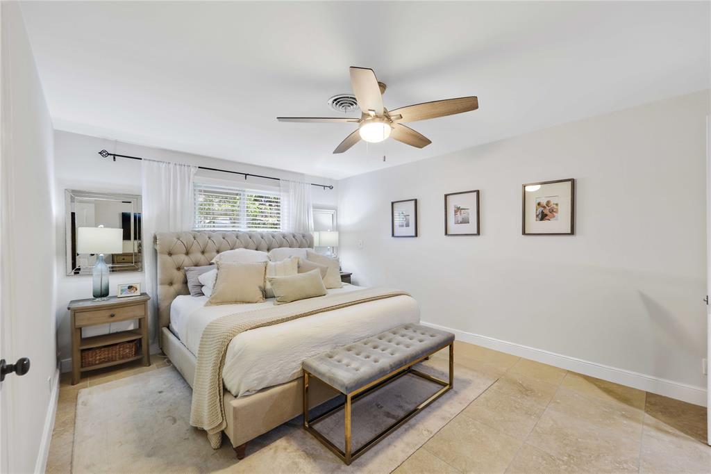 491 Northwest 13th Drive Boca Raton, FL 33486 - Photo 22 of 48 a bedroom with a bed a chandelier and a window