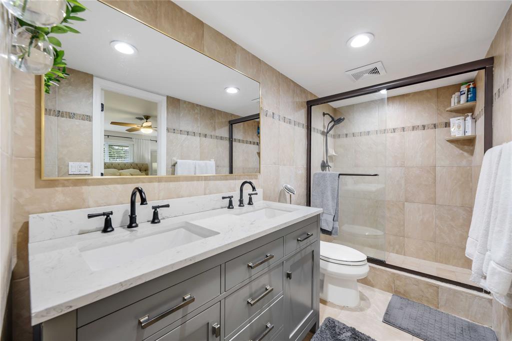 491 Northwest 13th Drive Boca Raton, FL 33486 - Photo 24 of 48 a bathroom with a double vanity sink toilet mirror and shower