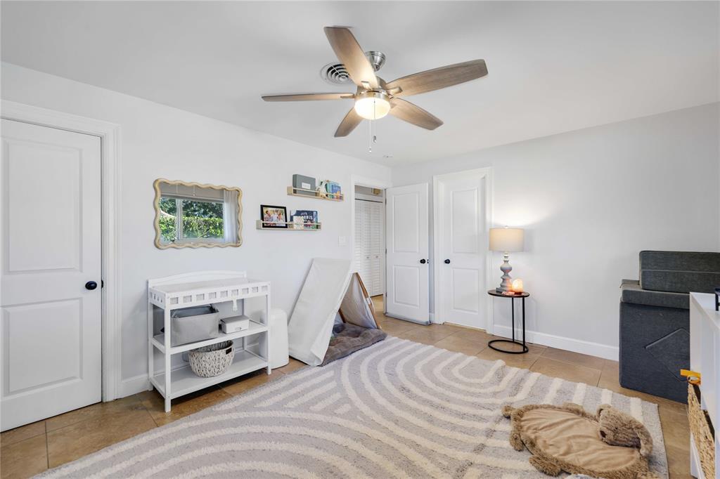 491 Northwest 13th Drive Boca Raton, FL 33486 - Photo 26 of 48 a bedroom with a bed and a chandelier