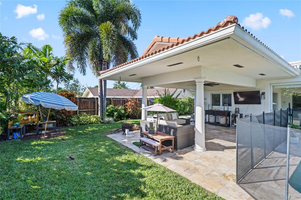 491 Northwest 13th Drive Boca Raton, FL 33486 - Photo 41 of 48 a patio with a table and chairs under an umbrella