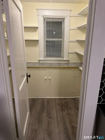 a view of a closet with wooden floor and a window