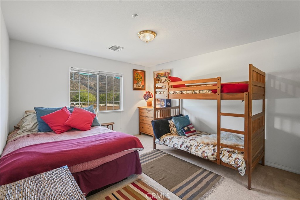 11709 Mint Canyon Road Agua Dulce, CA 91390 - Photo 20 of 49 a bedroom with a bed and wooden floor