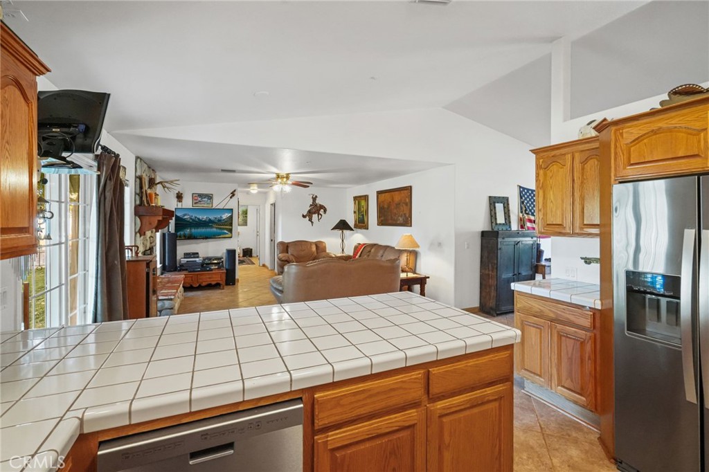 11709 Mint Canyon Road Agua Dulce, CA 91390 - Photo 8 of 49 a kitchen with kitchen island a counter top space a refrigerator and cabinets