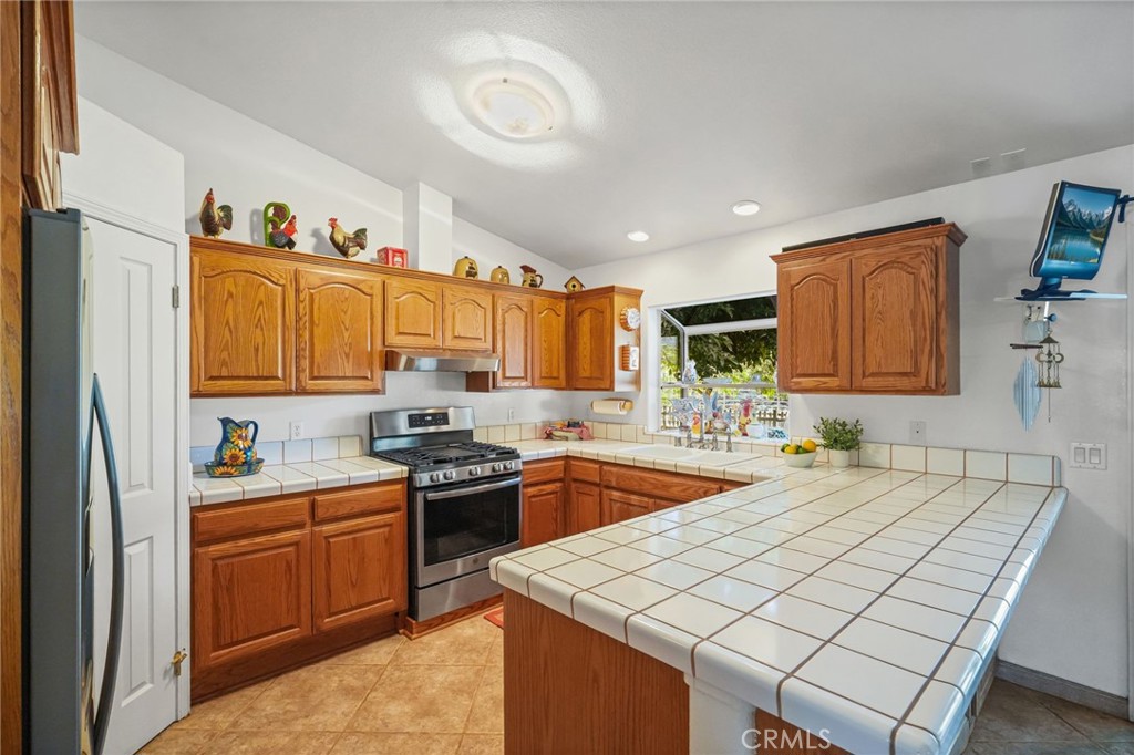 11709 Mint Canyon Road Agua Dulce, CA 91390 - Photo 9 of 49 a kitchen with stainless steel appliances granite countertop a sink stove and refrigerator