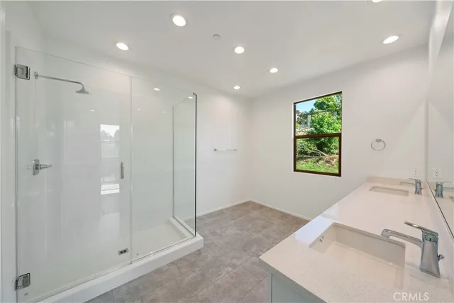 a bathroom with a shower sink and mirror