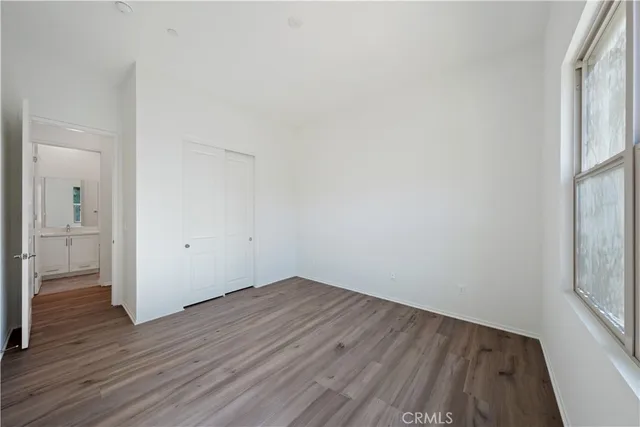 a view of a room with wooden floor and a window