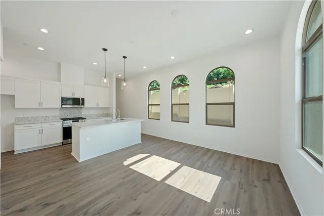 an empty room with windows and wooden floor