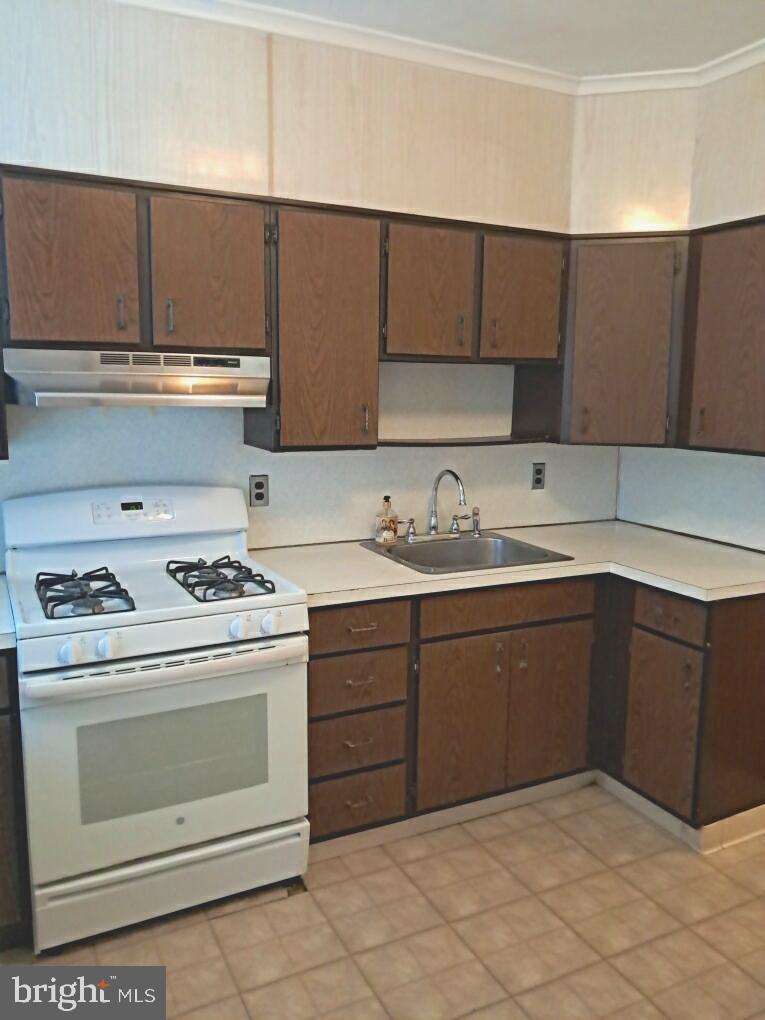 652 Jamestown Avenue Philadelphia, PA 19128 - Photo 11 of 13 a kitchen with a stove sink and cabinets