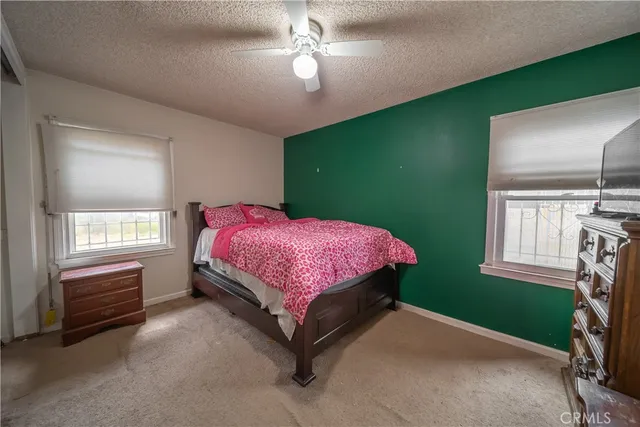a bedroom with a bed dresser and a window