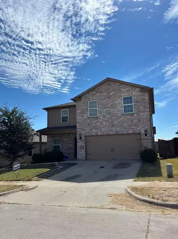 a front view of a house with a yard and a garage