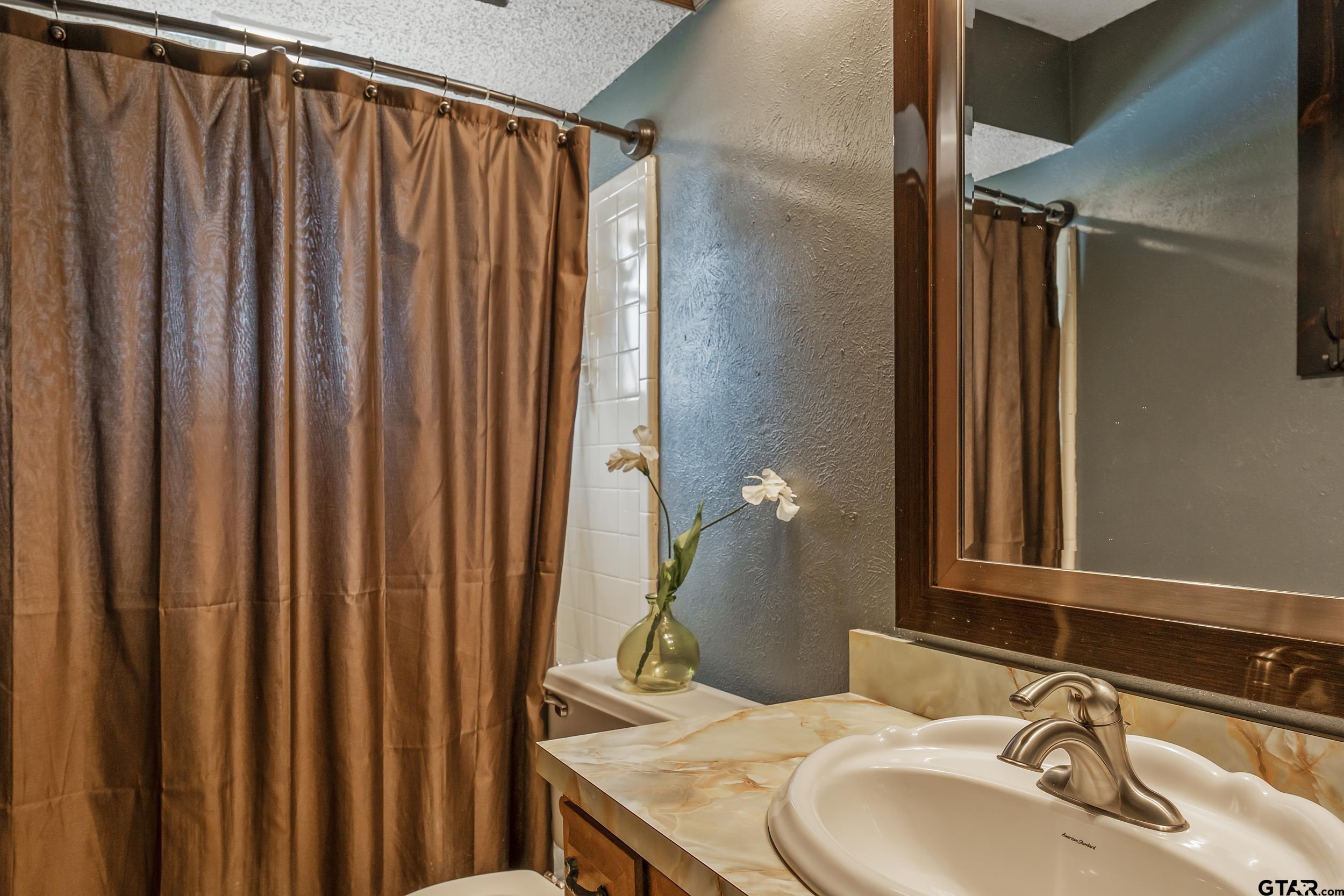 449 Ruth Street Hawkins, TX 75765 - Photo 23 of 33 a bathroom with a sink and a mirror