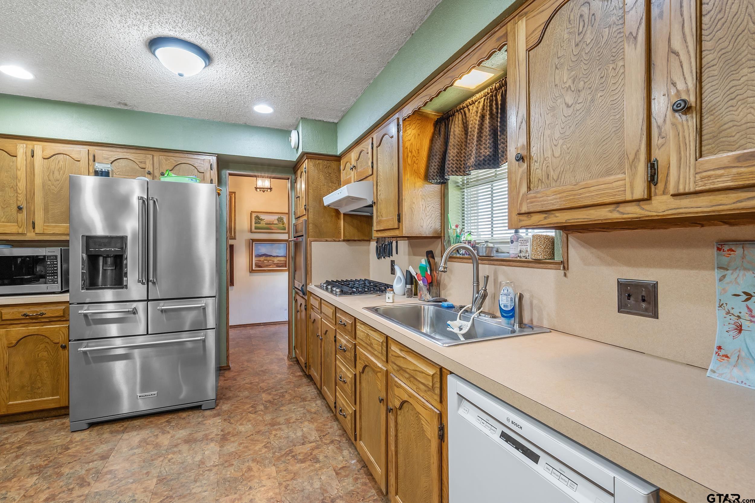 449 Ruth Street Hawkins, TX 75765 - Photo 5 of 33 a kitchen with stainless steel appliances a refrigerator sink and cabinets