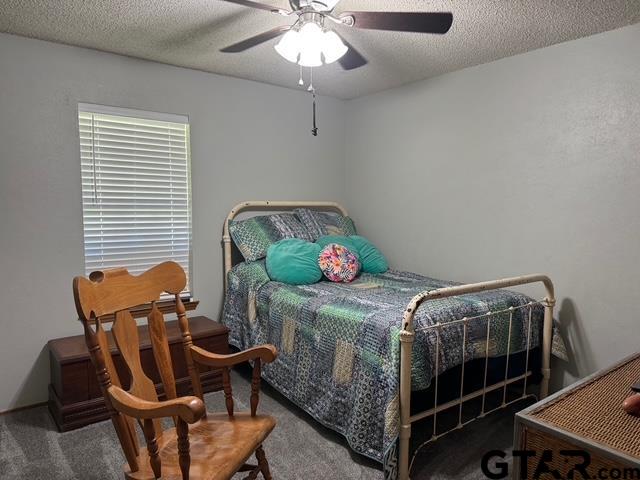 449 Ruth Street Hawkins, TX 75765 - Photo 6 of 33 a bedroom with a bed and a chandelier
