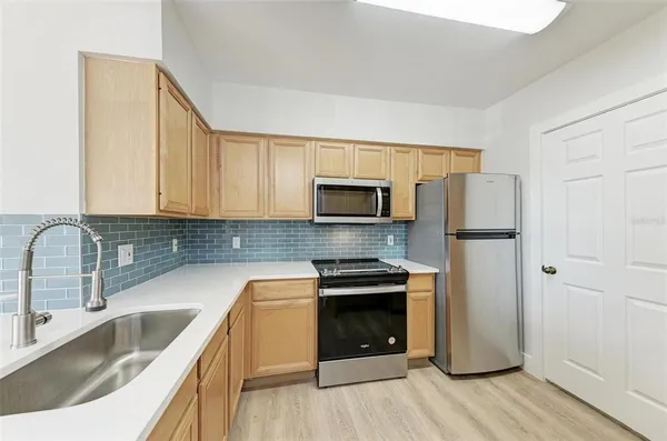 a kitchen with stainless steel appliances granite countertop a refrigerator sink and stove
