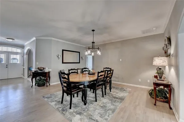 a kitchen with a dining table chairs sink and cabinets