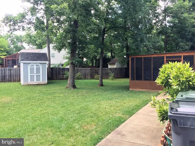 a view of a house with backyard and a tree