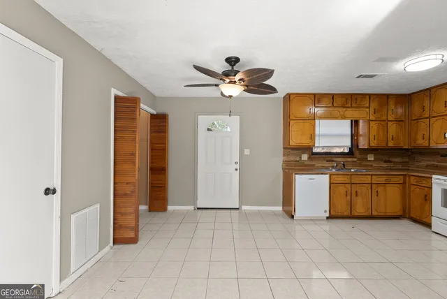 a view of a livingroom with a ceiling fan and wooden floor