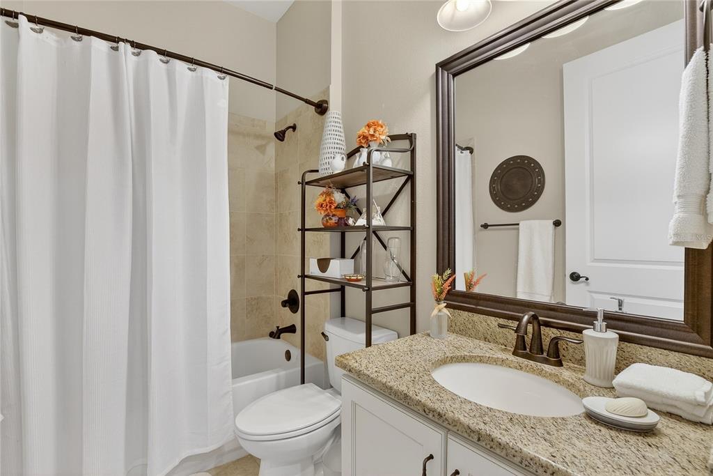 6020 Plover Meadow Street Lithia, FL 33547 - Photo 12 of 41 a bathroom with a granite countertop sink toilet and shower