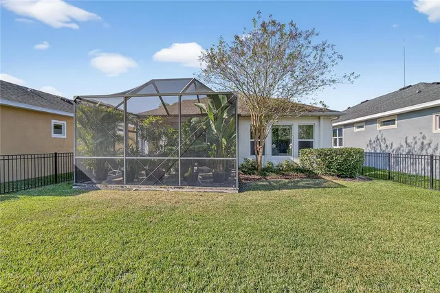 a view of a house with a yard and potted plants