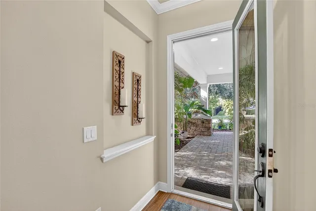 a kitchen with stainless steel appliances granite countertop a stove top oven a refrigerator a sink and white cabinets with wooden floor