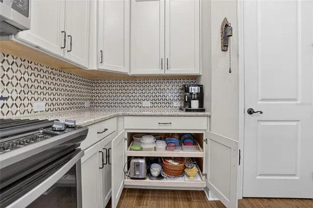 a kitchen with granite countertop a table chairs stainless steel appliances and cabinets