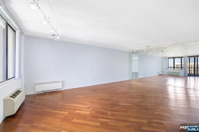 a view of a hallway with wooden floor and a living room
