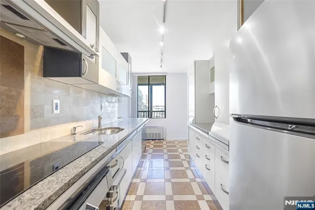 a spacious bathroom with a double vanity sink a large mirror and a bathtub