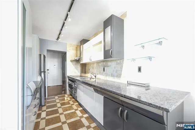 a view of a kitchen with refrigerator and wooden floor