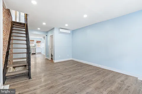 an empty room with wooden floor stairs and stairs