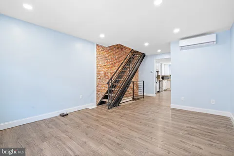 an empty room with wooden floor and stairs