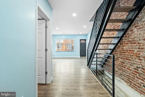 a view of a hallway with wooden floor and staircase