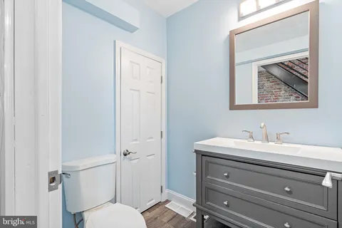 a bathroom with a toilet a sink and mirror