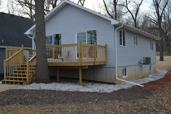 a view of house with a yard and wooden fence