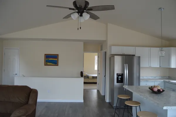 a view of an empty room with wooden floor and windows