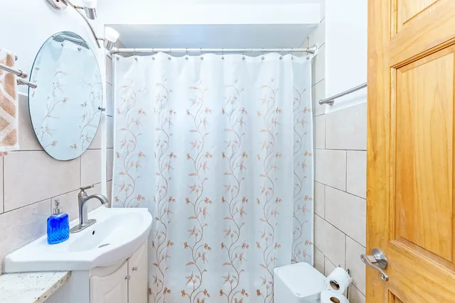 a bathroom with a sink a toilet and shower curtain