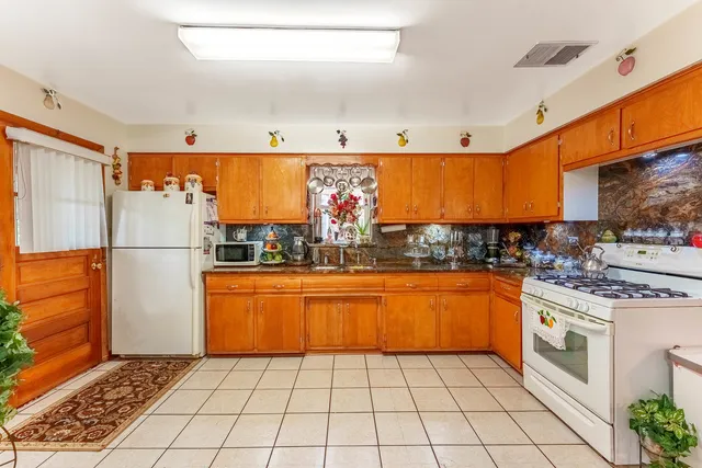 a kitchen with stainless steel appliances granite countertop a refrigerator a stove a sink and a microwave