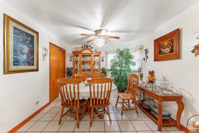 a view of a dining room with furniture and a chandelier fan