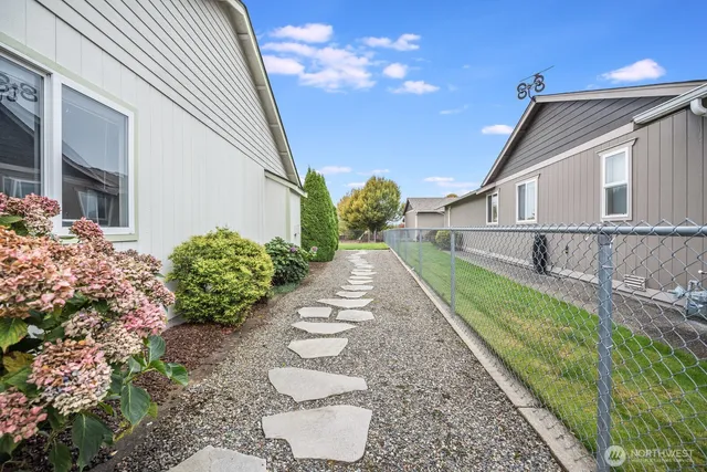 a view of an empty room with wooden floor and windows