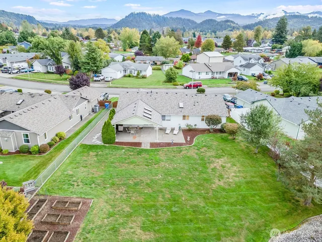 a view of a patio with a table and chairs and a barbeque