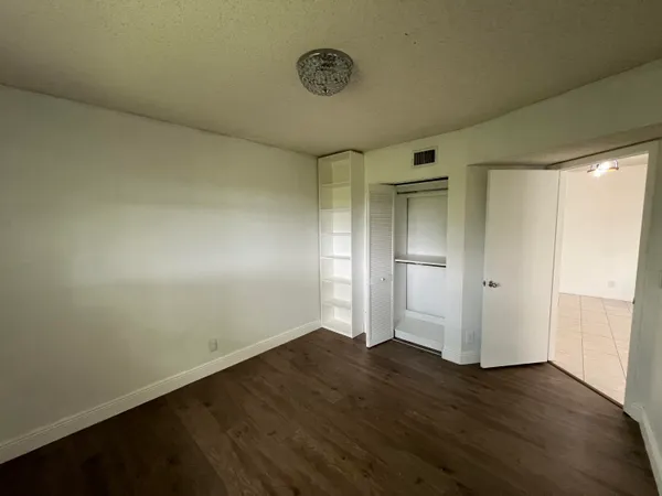 an empty room with wooden floor and a window